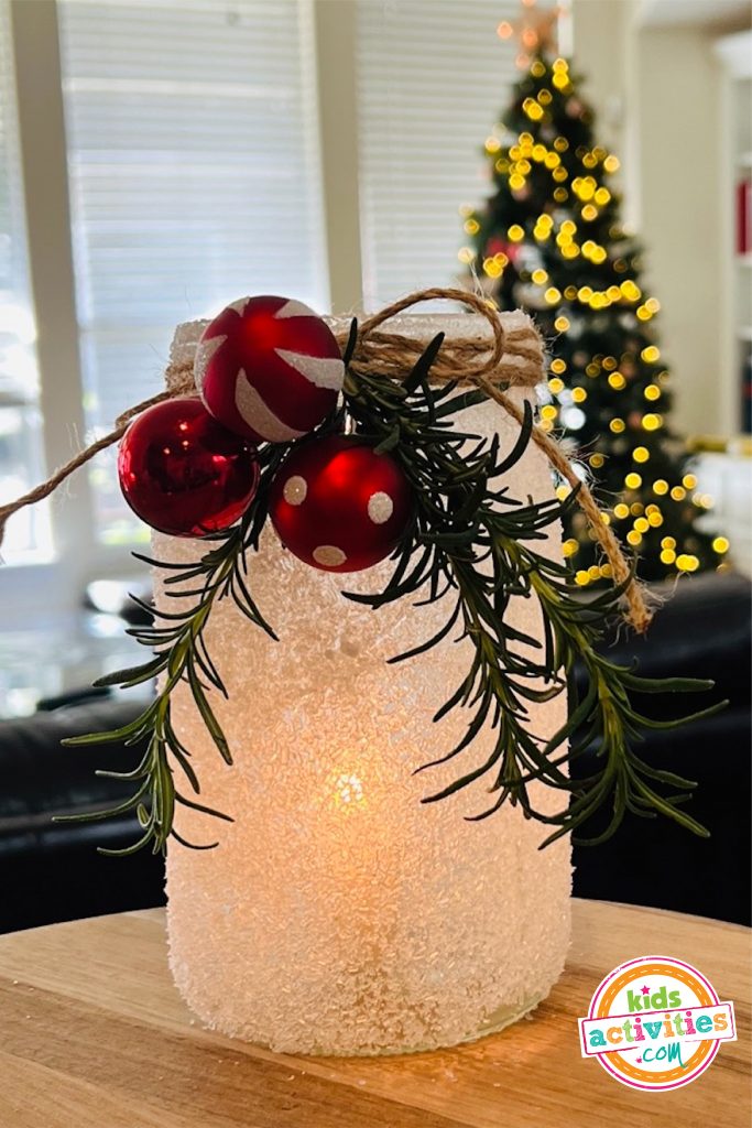 Frosted candle Christmas craft- Image shows a finished christmas craft on a table. from Kids Activities Blog