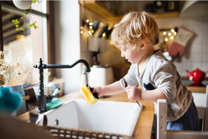 Giant age appropriate chores for kids guide - Kids activities Blog - toddler washing dishes from stool