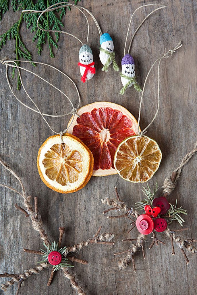 natural Christmas ornaments- Image shows sliced fruits ornamets with thread across them and christmas decorations.