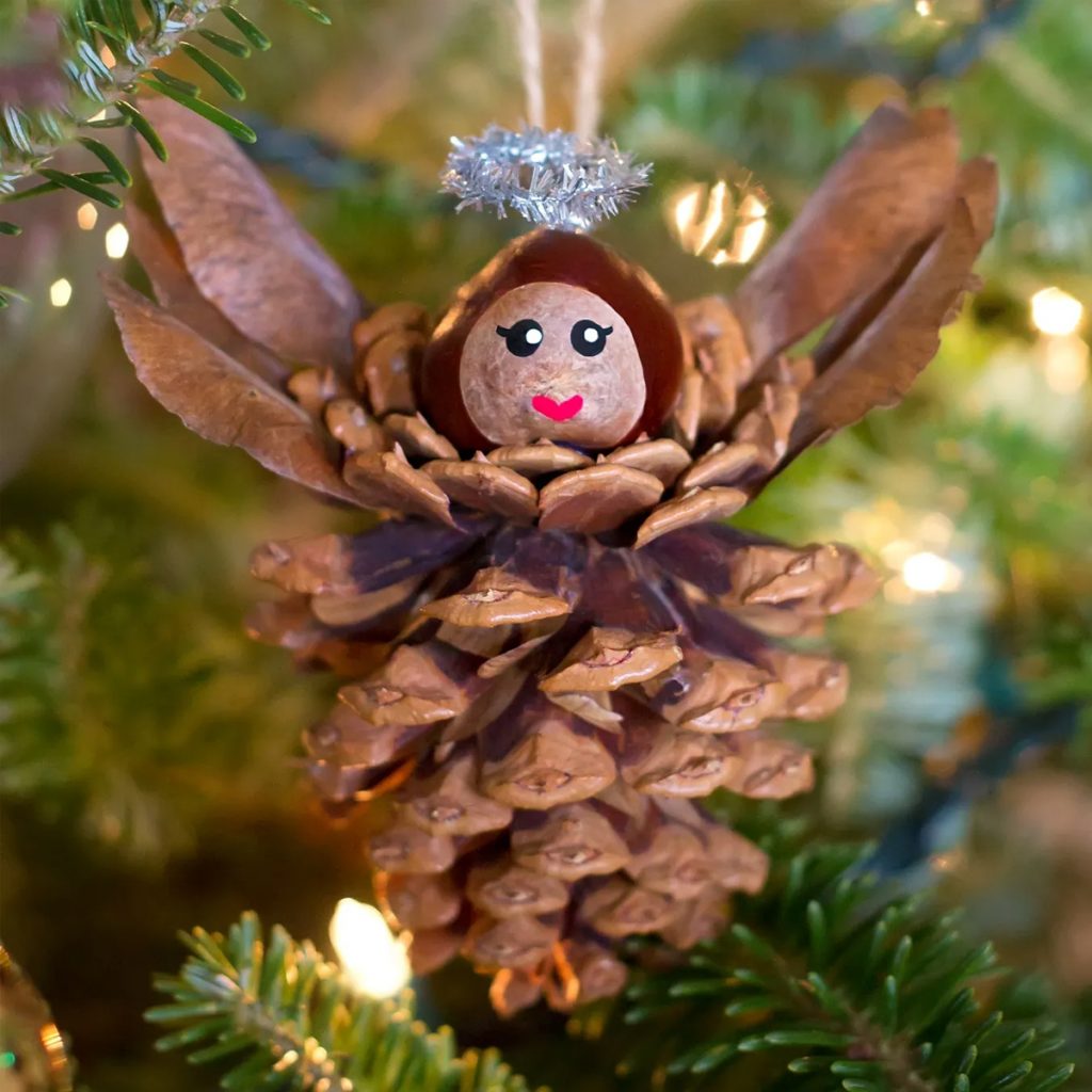 natural Christmas ornaments- Image shows a pinecone angel hanging from a tree.