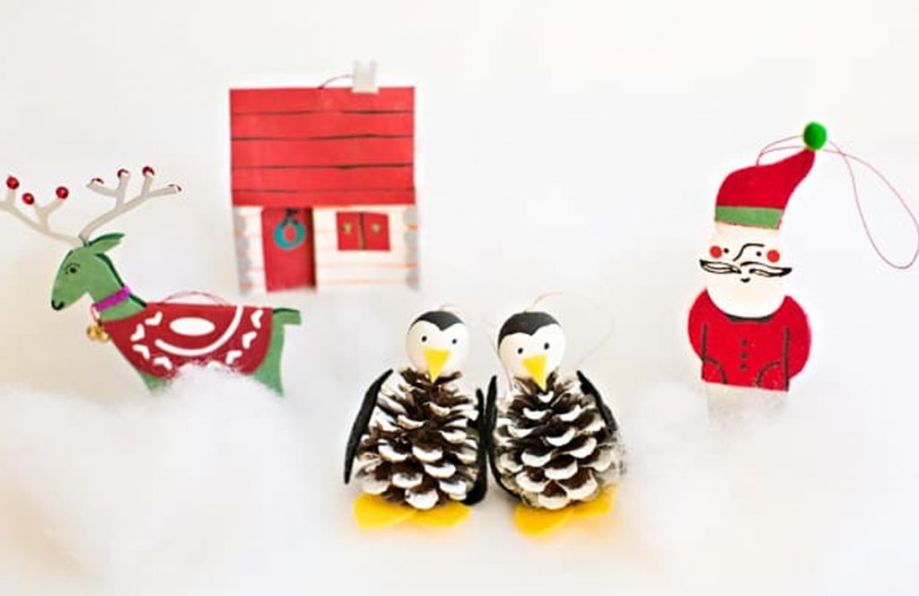 natural Christmas ornaments- Image shows pinecone ornaments decorated like penguins or santa.