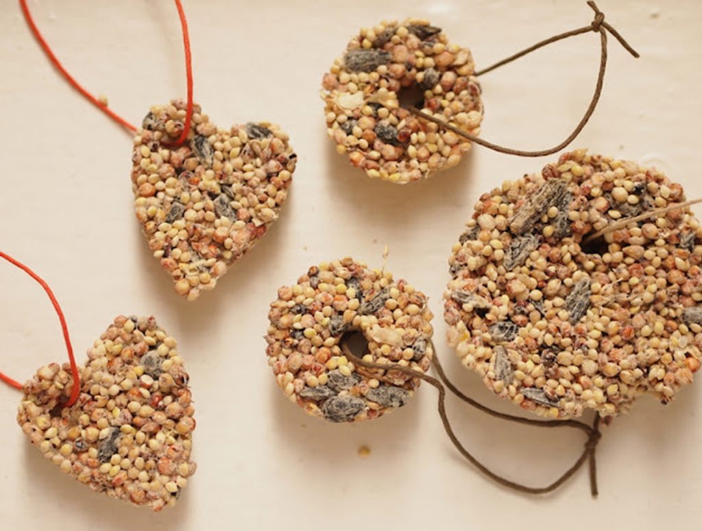 natural Christmas ornaments- Image shows several DIY birdseed ornaments with thread.