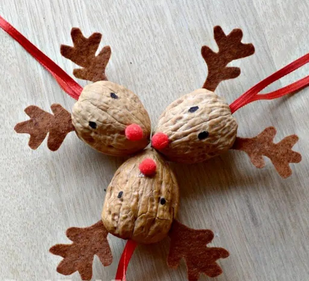 natural Christmas ornaments- Image shows three walnut crafts decorated like reindeers.