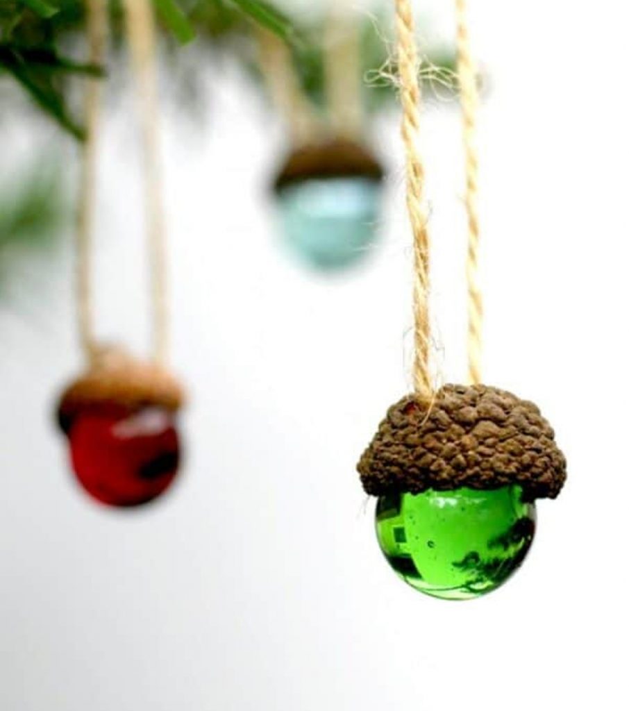 natural Christmas ornaments- Image shows rustic acorn marble ornaments hanging from a tree.