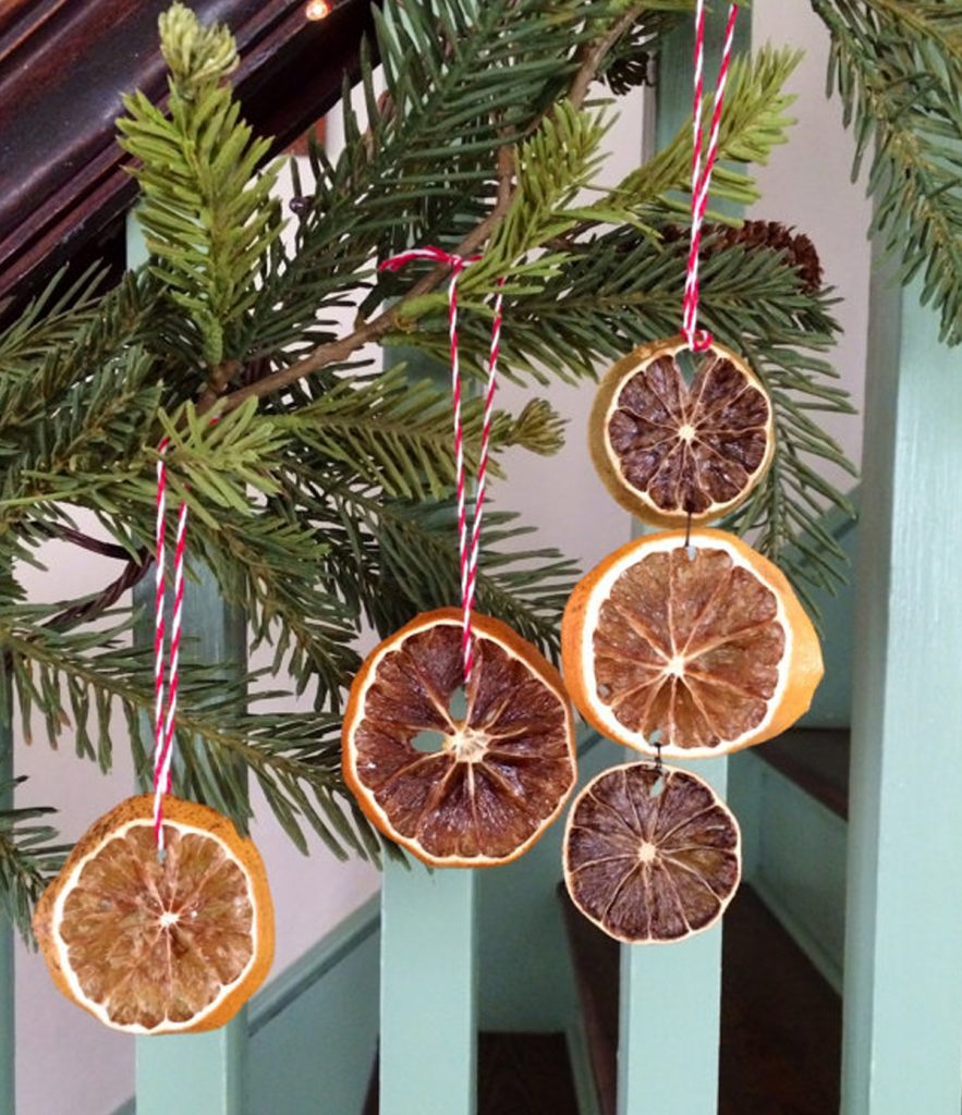 natural Christmas ornaments- Image shows dried oranges ornaments hanging from a christmas tree.