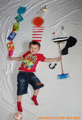 Cat in the hat photo shoot against a white sheet with a boy holding silly things from the cat in the hat book