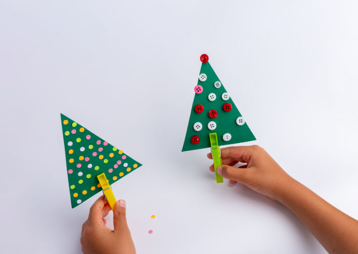 paper christmas tree craft - decorated craft paper triangles with clothes pin trunks