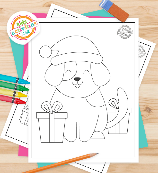 Puppy Christmas Coloring Pages printed pdf against a wood background with pencil and crayons- kids activities blog