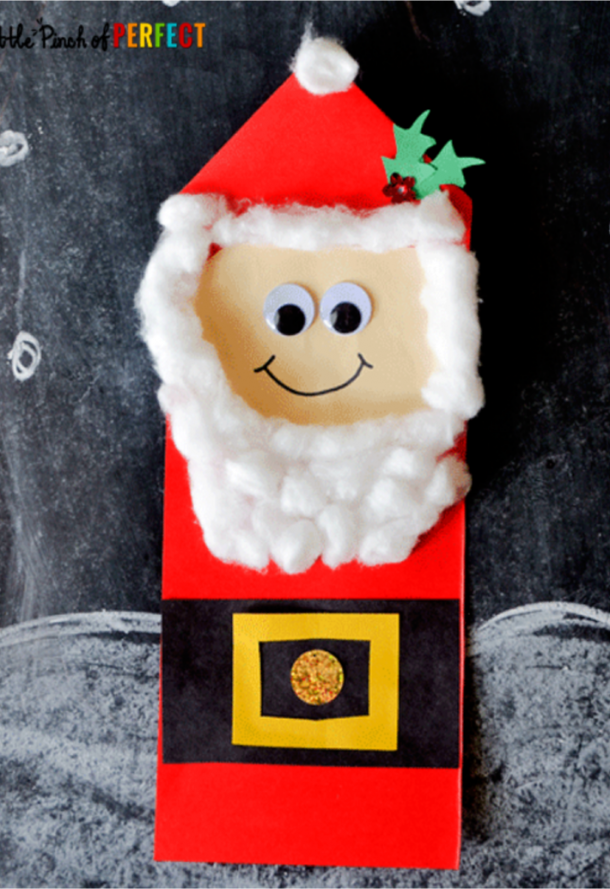 Christmas Santa crafts for kids with a paper santa with a red suit, black belt and white cotton beard.